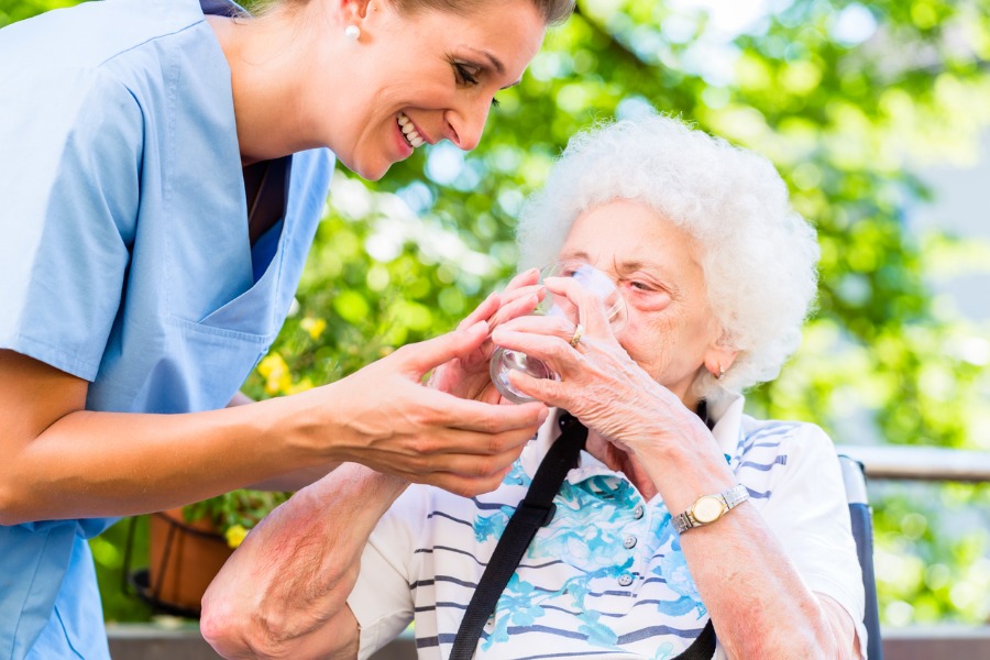 caregiver_giving_water_to_senior